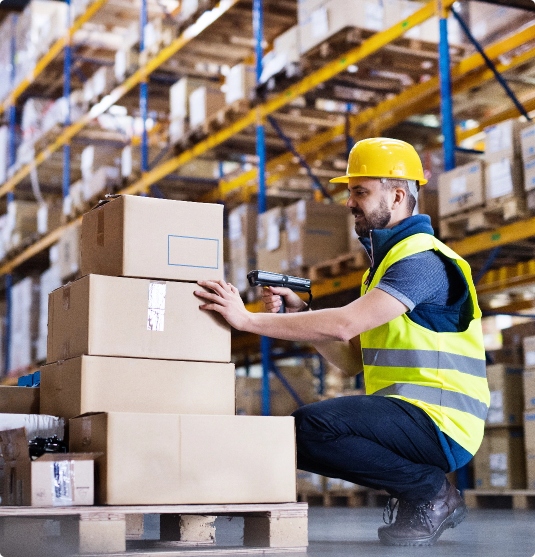 A man scanning boxes in a warehouse.